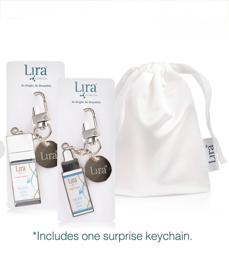 Lira London gift set featuring two keychains on display cards and a white drawstring bag, with text noting one surprise keychain is included.